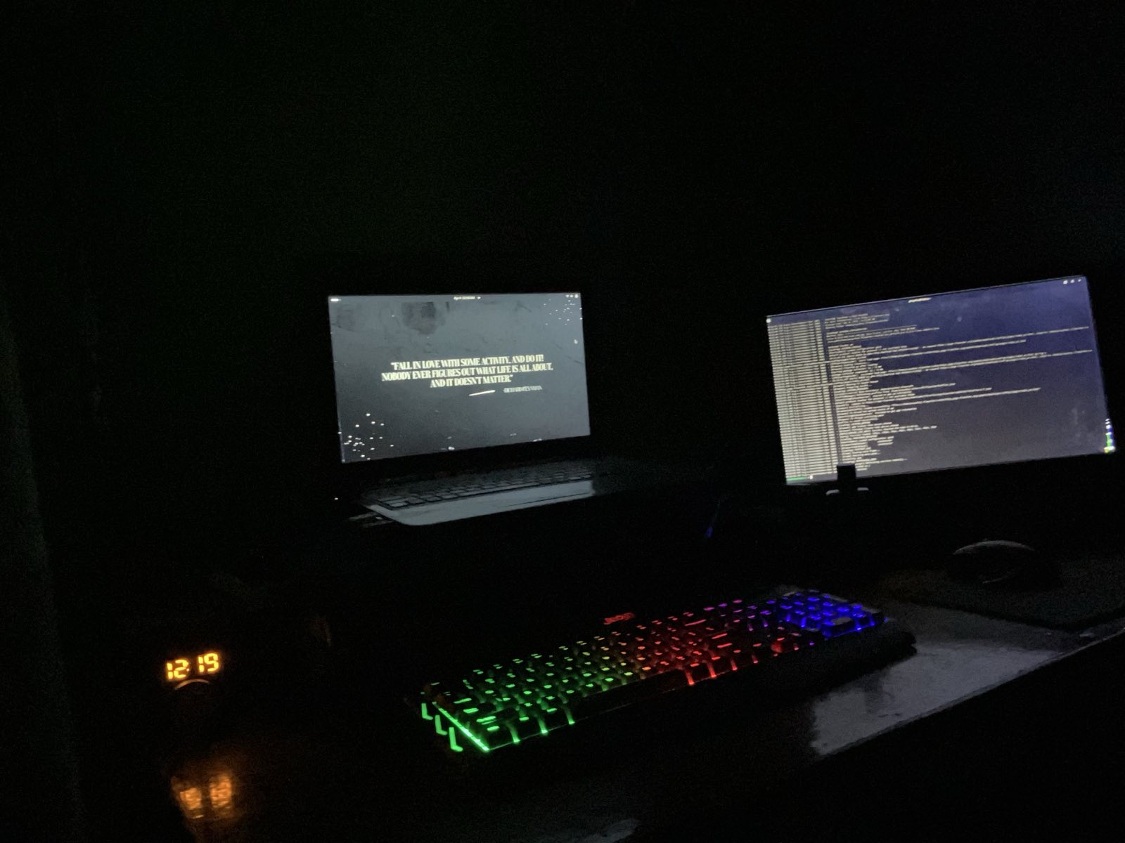 A dark desk with a laptop and monitor